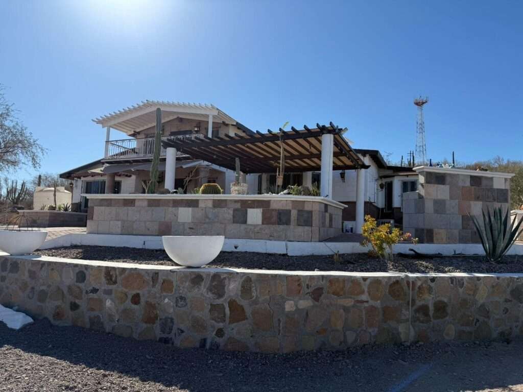 Loreto Centro Beautiful property for sale located along the Transpeninsular Highway in a peaceful, low-density area. Set on a generous 3,016 m² lot with 201.50 m² of construction, this home offers spacious, light-filled interiors with elegant marble floors and high ceilings with exposed wood beams that enhance its warm, inviting character.Fully furnished with high-quality pieces, the home features an open-concept living, dining, and kitchen area designed for both comfort and functionality. Upstairs, a cozy TV lounge opens to a private balcony with stunning – Carr. Transpeninsular, Loreto, BS