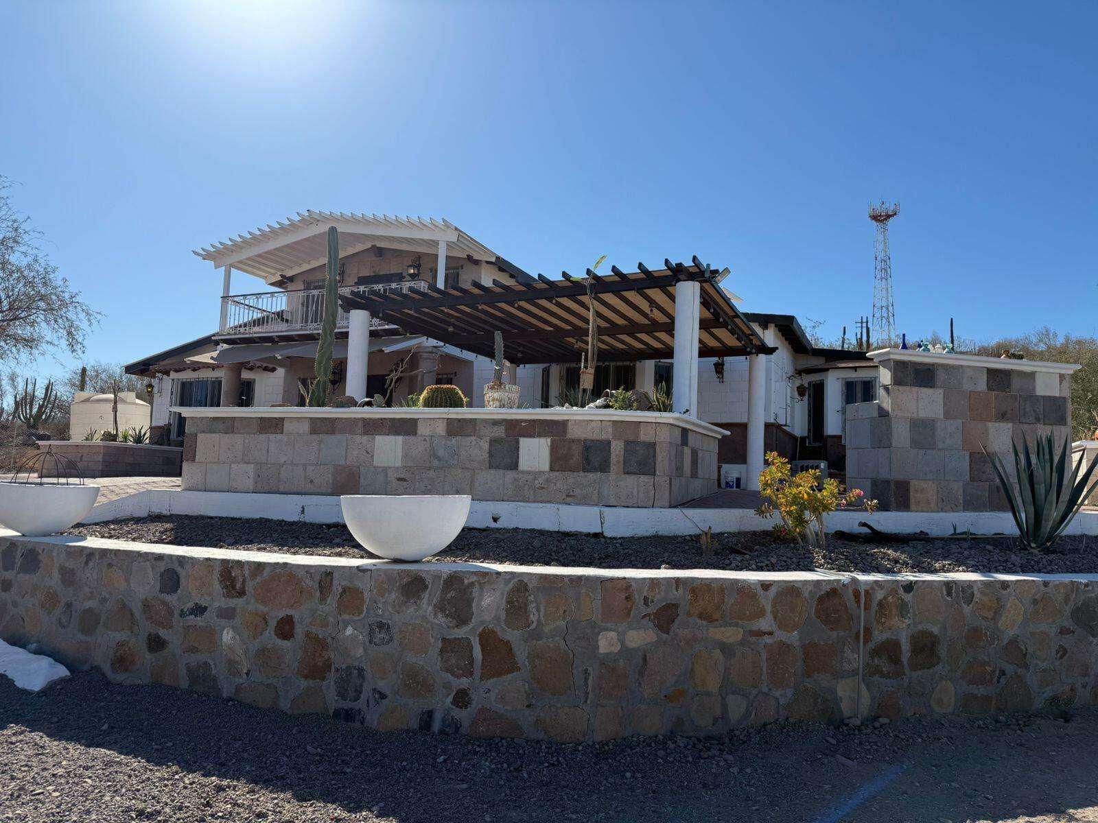 Loreto Centro Beautiful property for sale located along the Transpeninsular Highway in a peaceful, low-density area. Set on a generous 3,016 m² lot with 201.50 m² of construction, this home offers spacious, light-filled interiors with elegant marble floors and high ceilings with exposed wood beams that enhance its warm, inviting character.Fully furnished with high-quality pieces, the home features an open-concept living, dining, and kitchen area designed for both comfort and functionality. Upstairs, a cozy TV lounge opens to a private balcony with stunning for sale